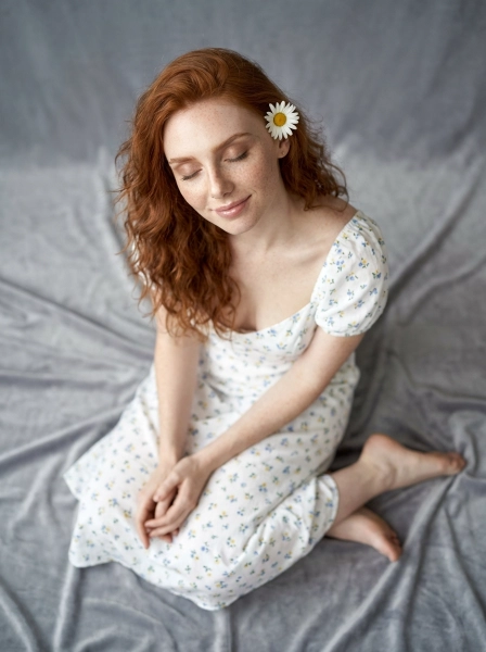 A_woman_with_wavy_red_hair_and_freckles_wearing_wh-1774496617713